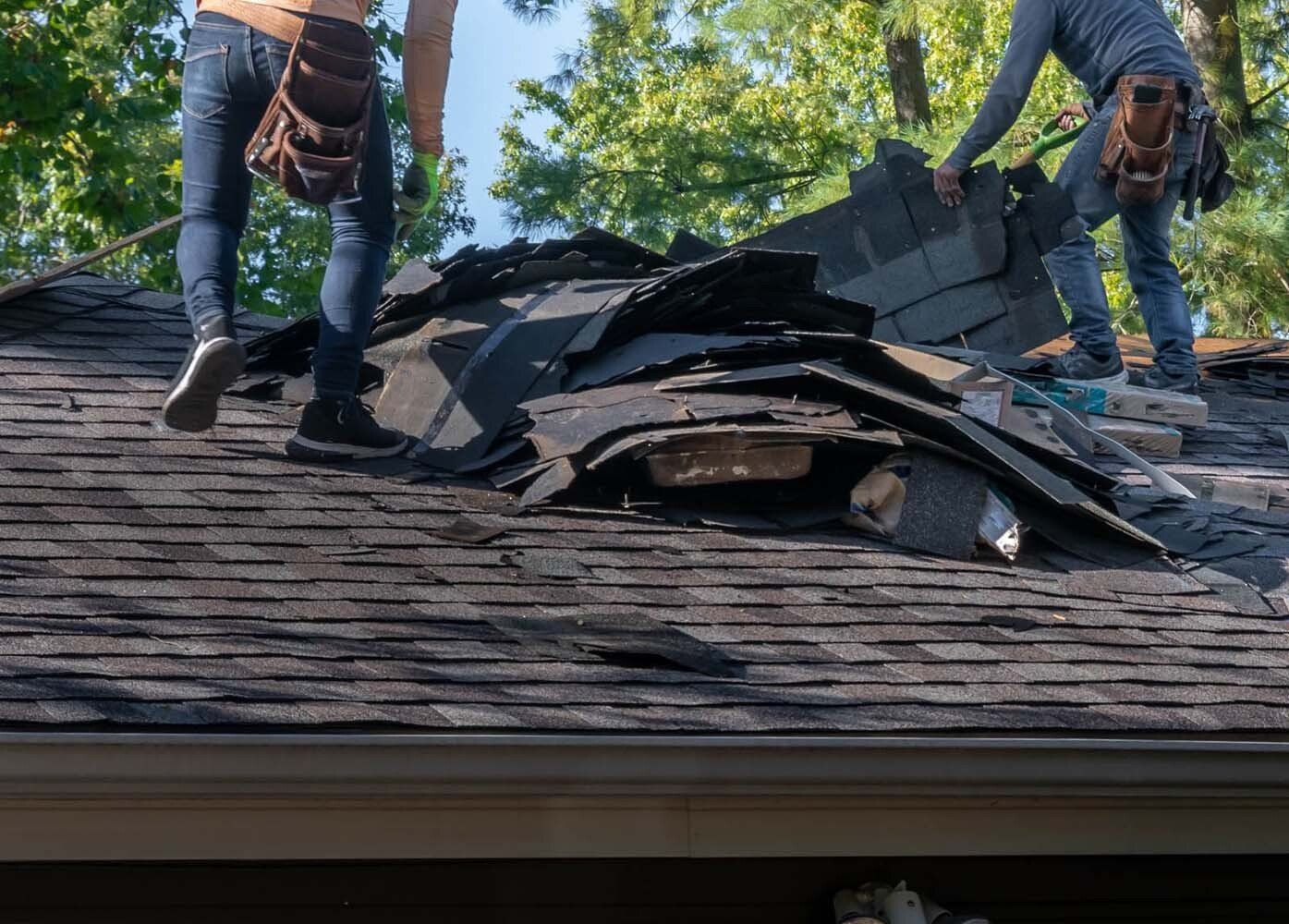 Deux couvreurs dépannant une toiture cassée