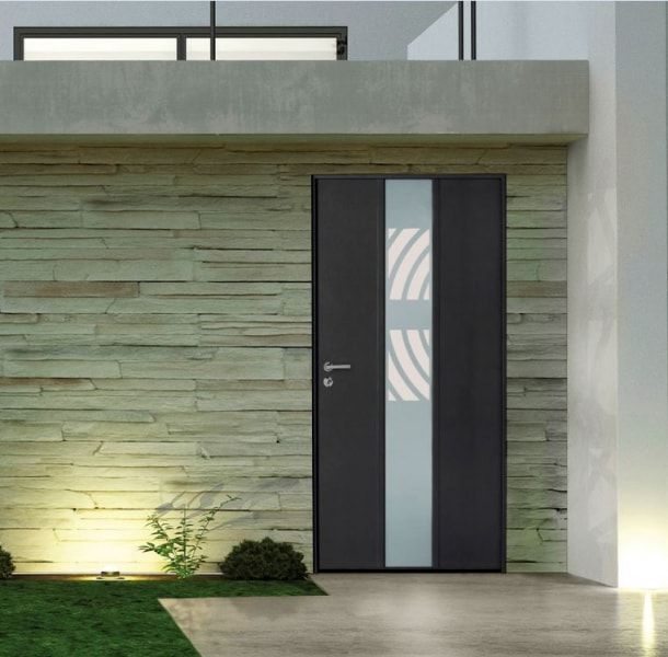 Une porte moderne gris foncé avec un panneau de verre vertical orné d'un motif incurvé, intégrée à un mur extérieur revêtu de pierre.
