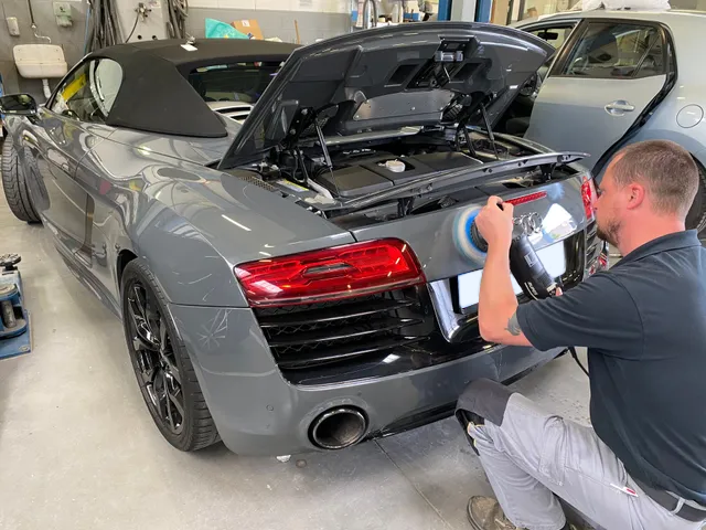 Carrossier d'Auto H premium en train de polir une carroserie
