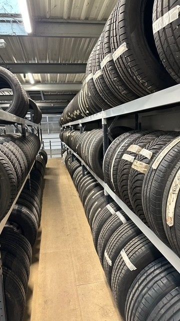 Des étagères de pneus empilés en rangées dans un entrepôt.