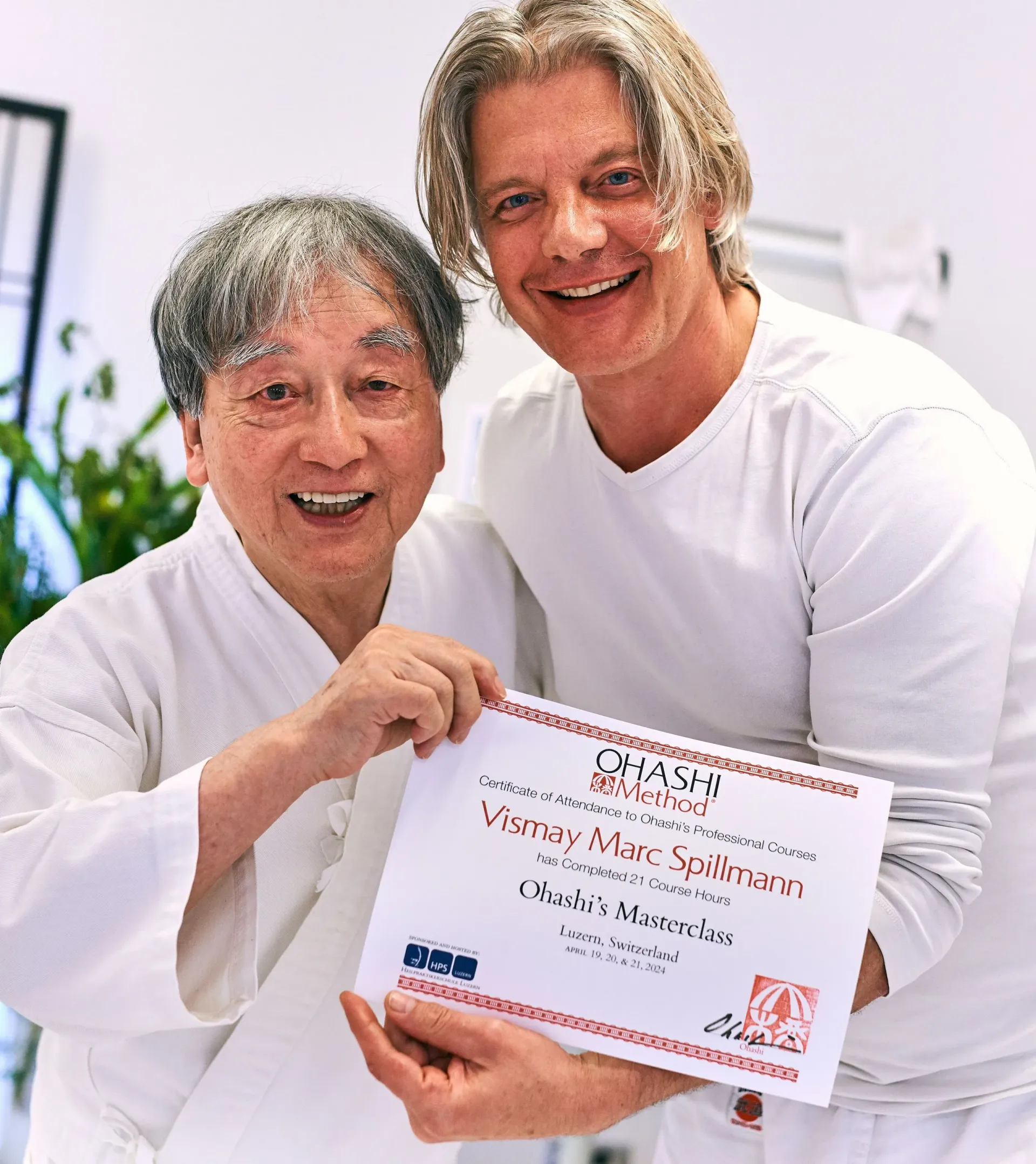 Zwei Männer posieren für ein Foto und einer hält eine Urkunde in der Hand