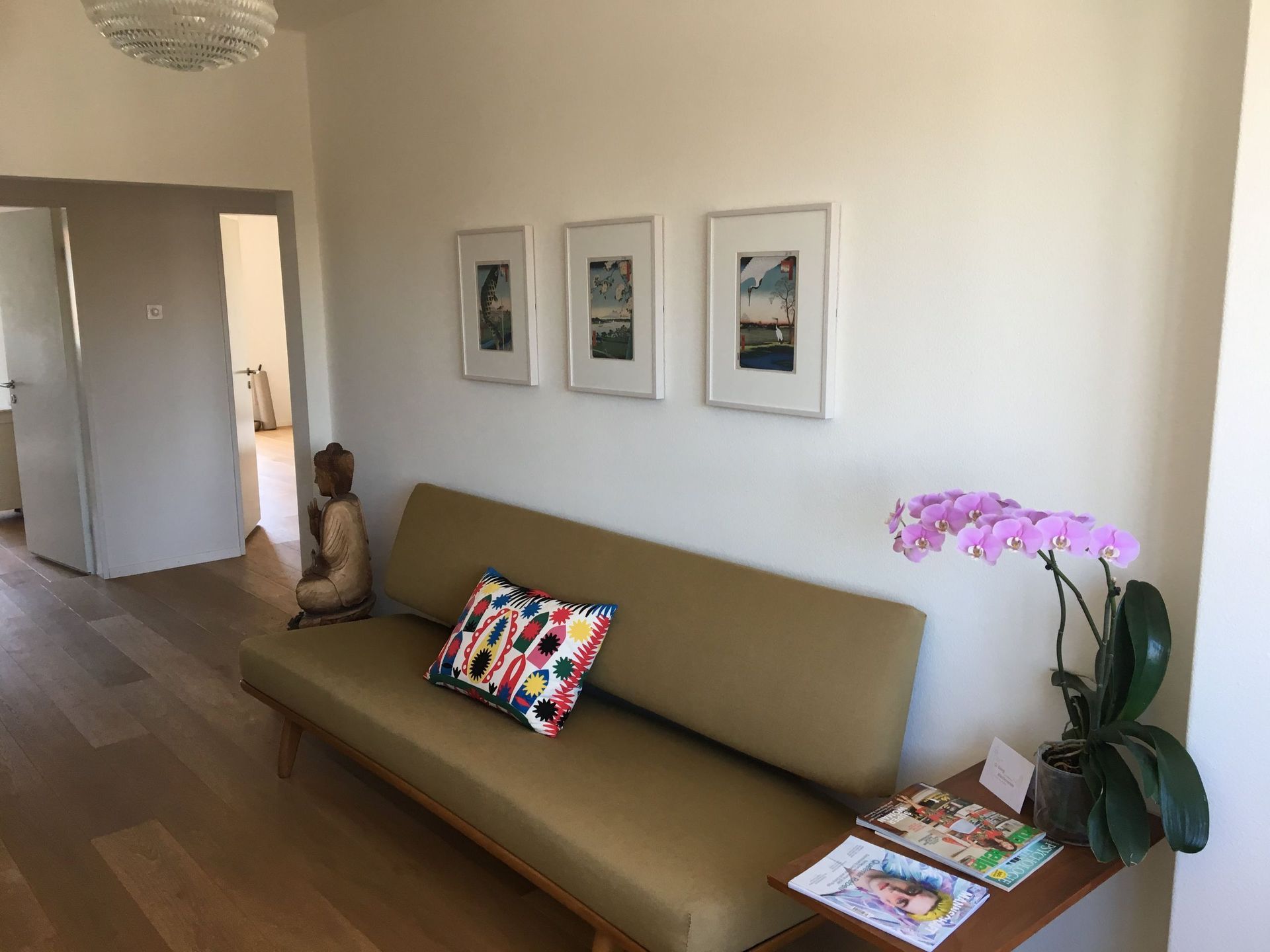 Ein Wohnzimmer mit einer Couch und einem Tisch mit Zeitschriften darauf.