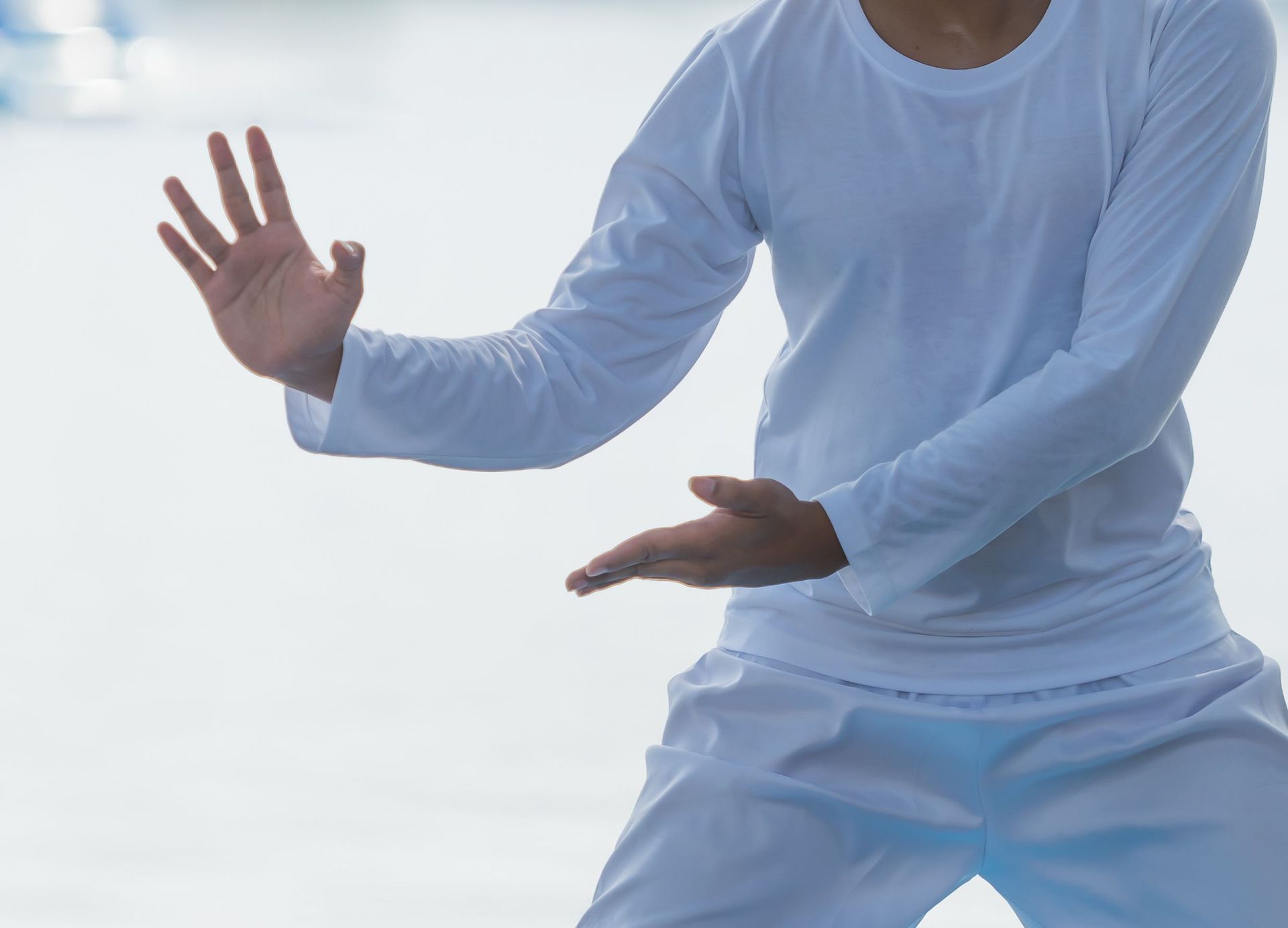 Ein Mann in einem weißen Hemd und weißen Hosen übt Kampfsport.