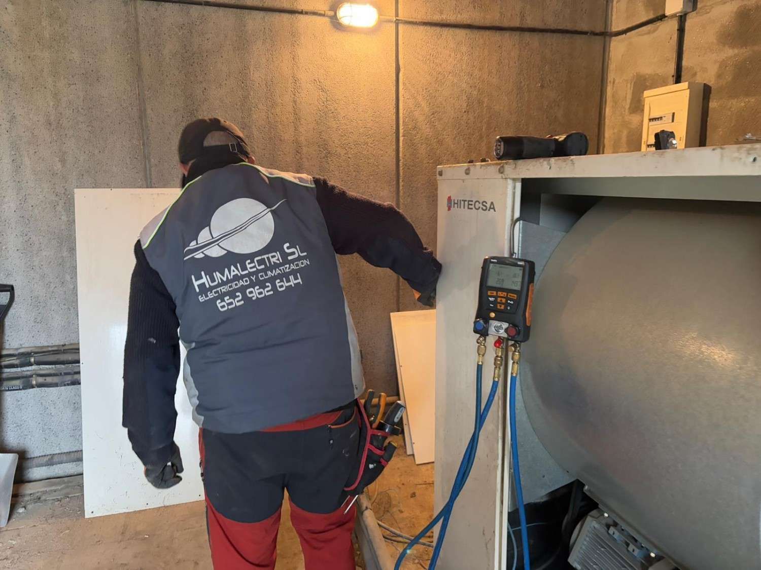 Aire acondicionado blanco montado en la pared sobre una ventana en una habitación luminosa.