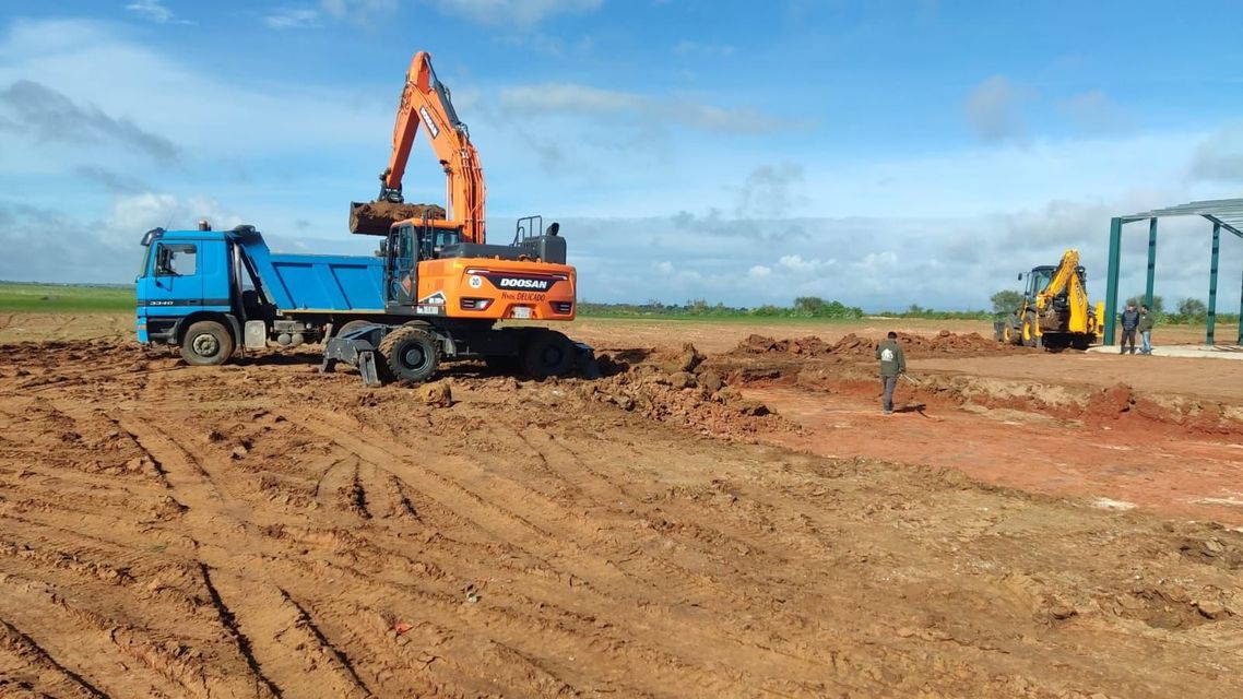 Un camión volquete está siendo cargado con tierra por una excavadora.