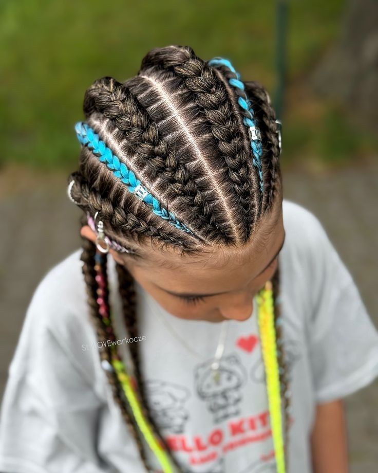 Primer plano de una trenza con detalles azules, vista desde arriba, sobre una camiseta gris de Hello Kitty.