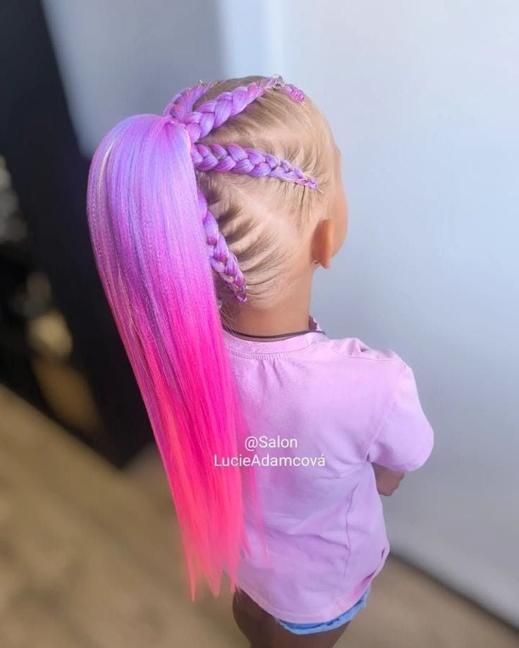 Muñeca con trenzas y cabello largo de color rosa a morado, vista desde atrás con una camisa lila.