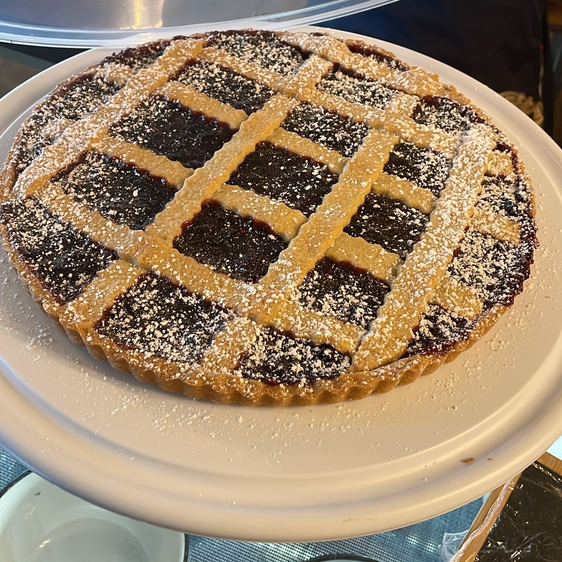 Un pastel con azúcar en polvo encima está en un plato blanco.