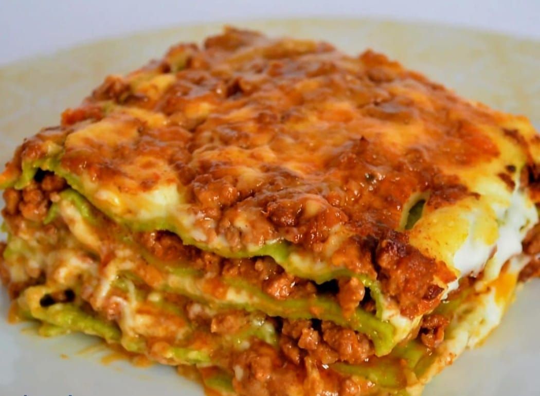 Un primer plano de una rebanada de lasaña en un plato.