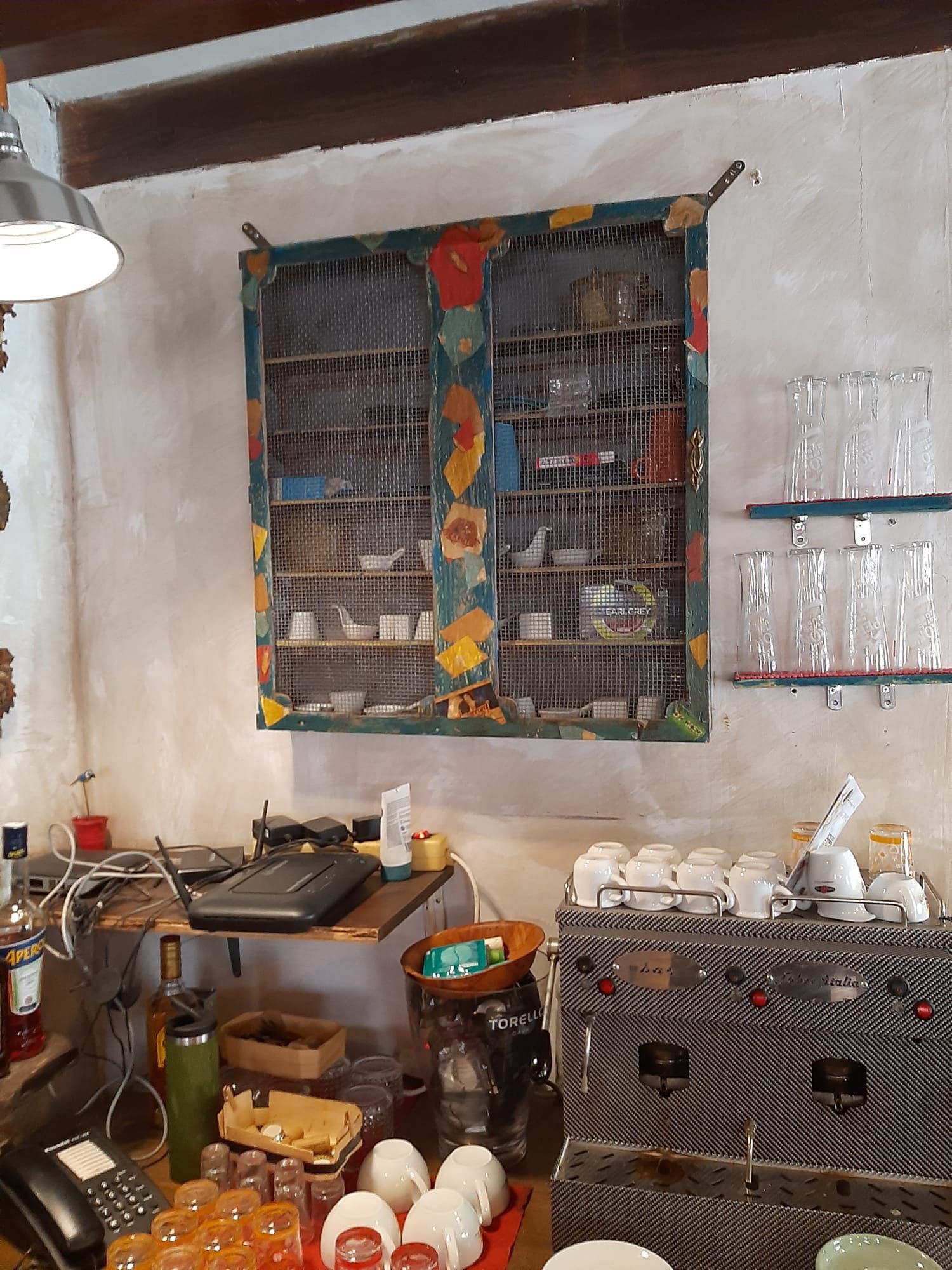 Una cocina con muchas tazas y vasos en la encimera.