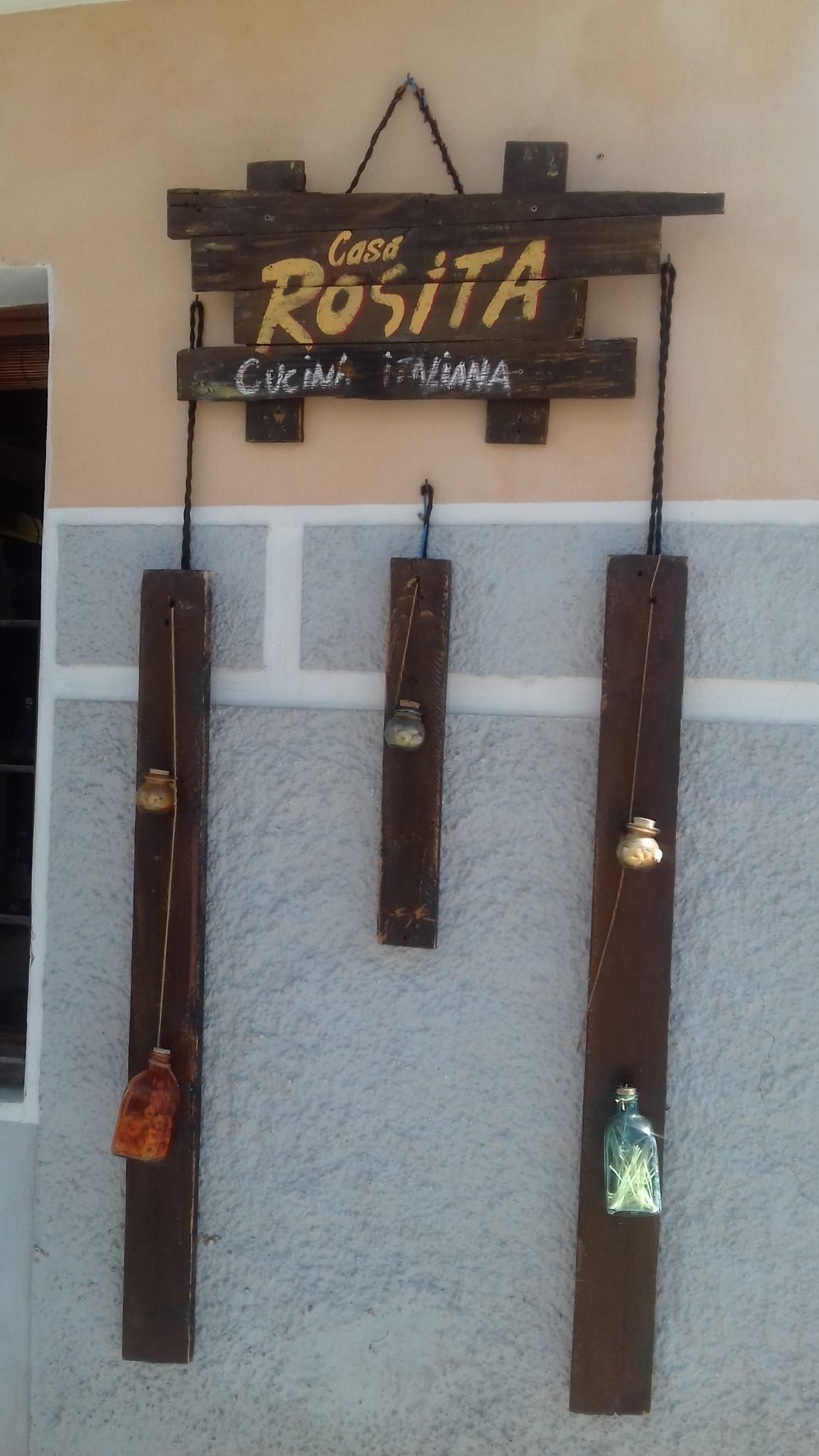 Un cartel de madera que dice Casa Rosita.