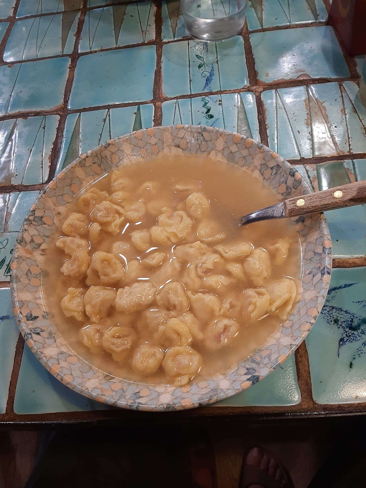 Un recipiente con comida y una cuchara dentro está sobre una mesa.