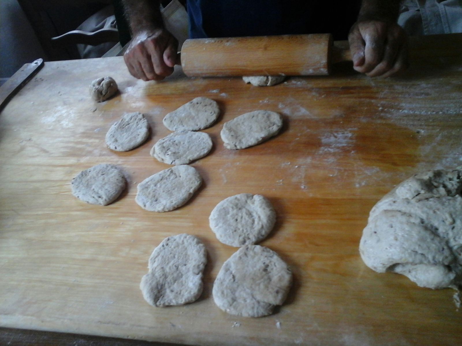 Una persona está amasando masa sobre una tabla de cortar de madera.