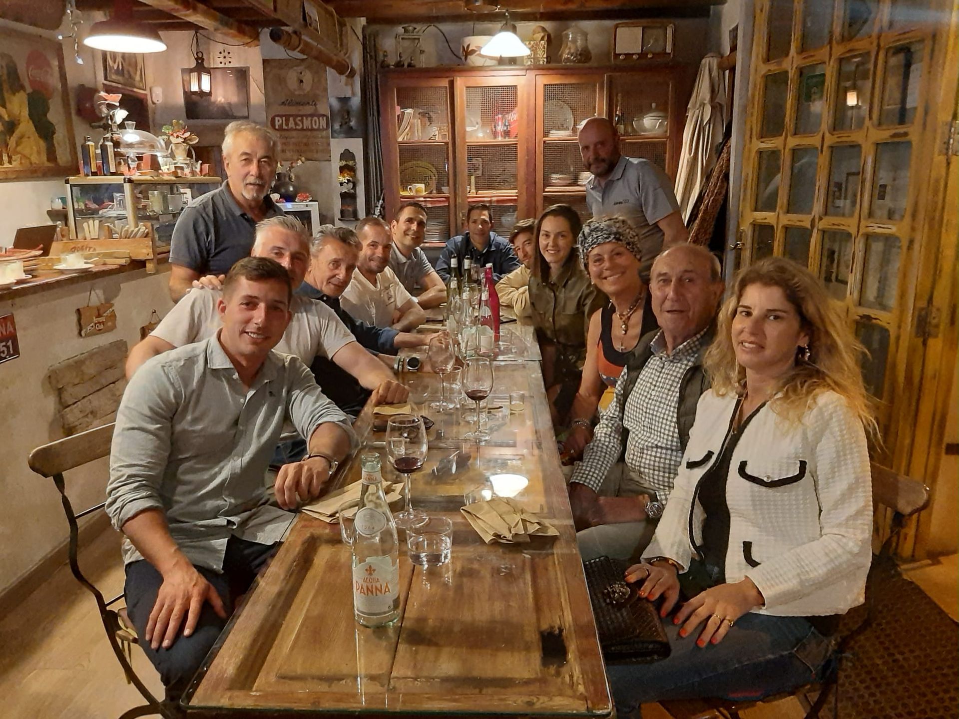 Un grupo de personas está sentado en una mesa larga en un restaurante.