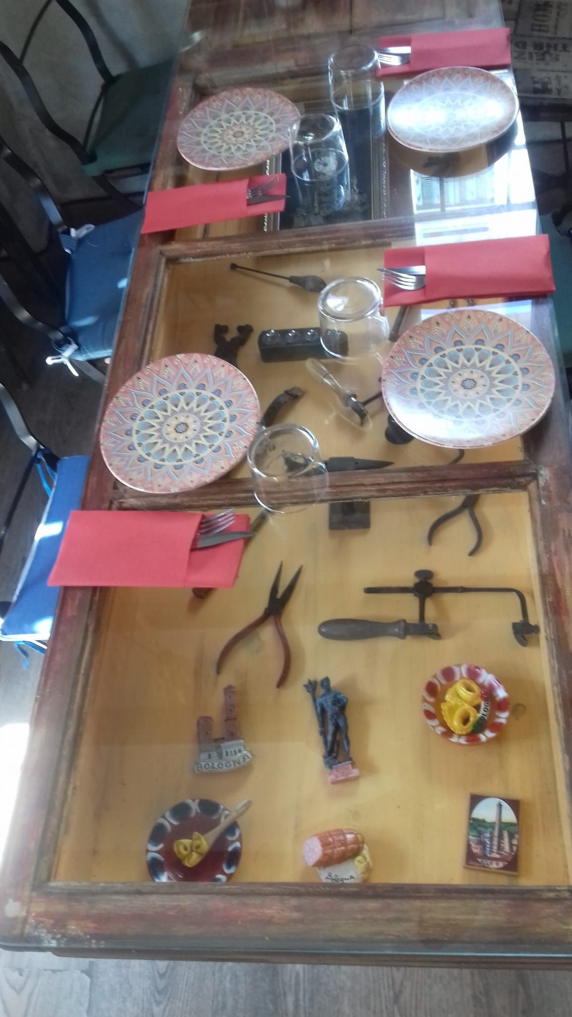 Una mesa con platos y servilletas y una exposición de herramientas sobre ella.