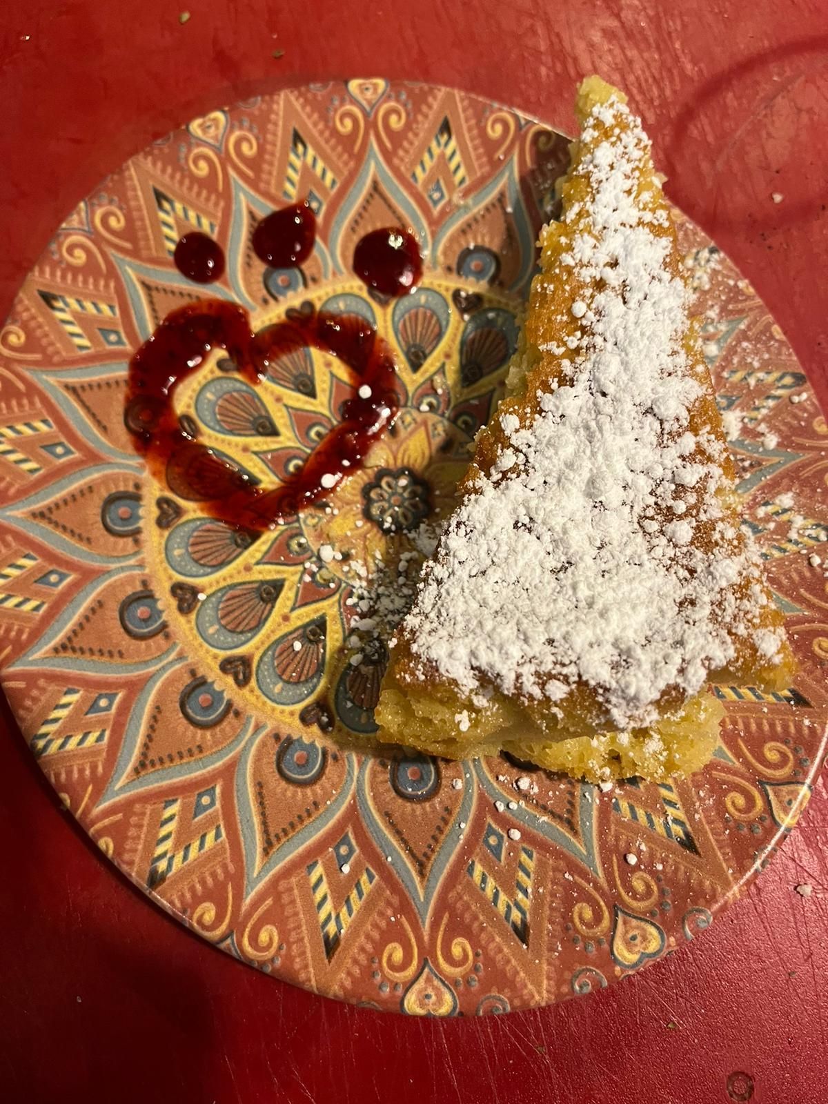 Un plato de comida con azúcar en polvo y un corazón encima.