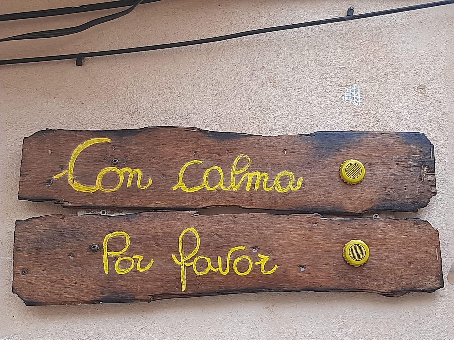 Un cartel de madera que dice con calma por favor