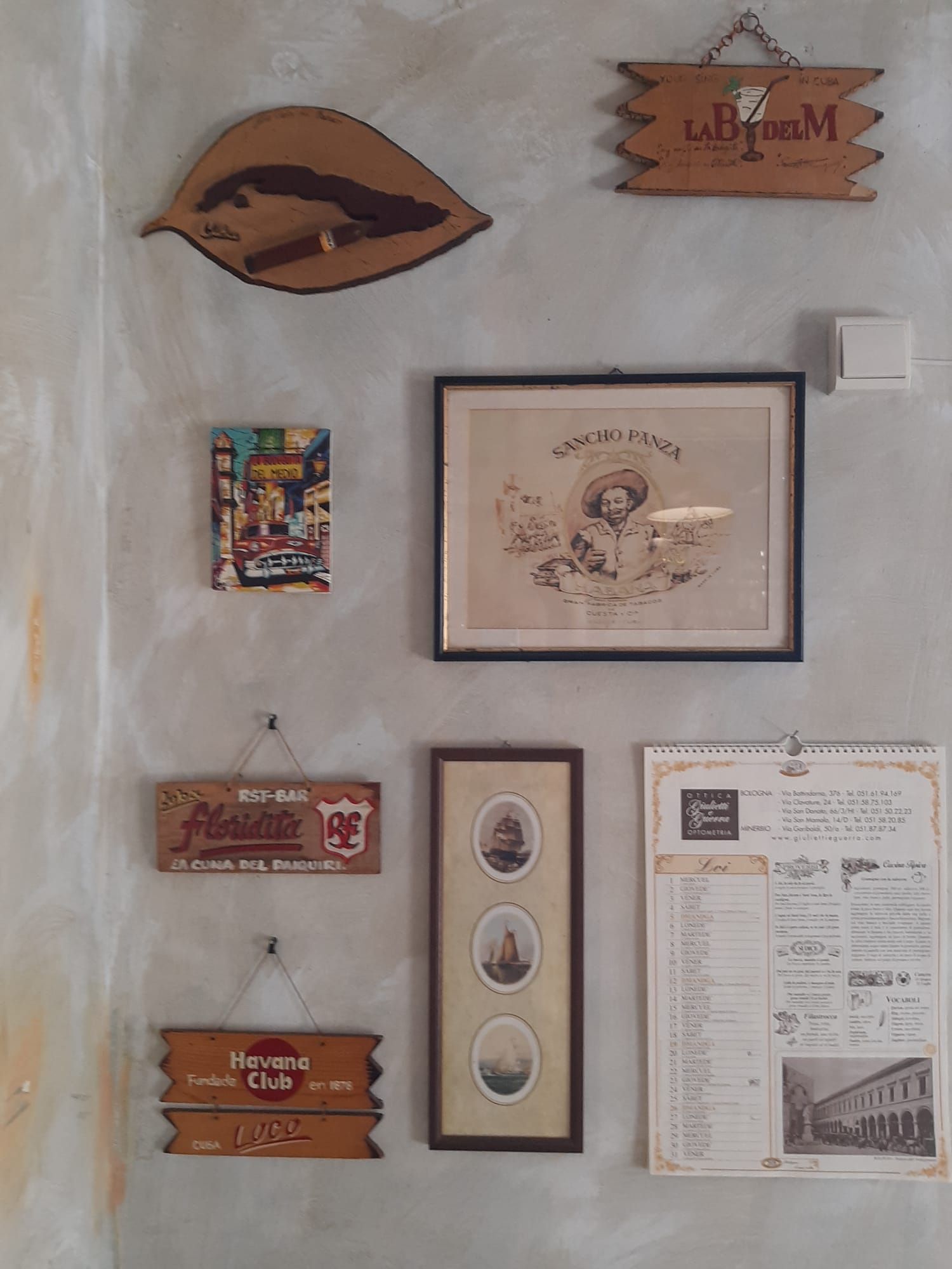 Una pared con muchos cuadros y carteles.