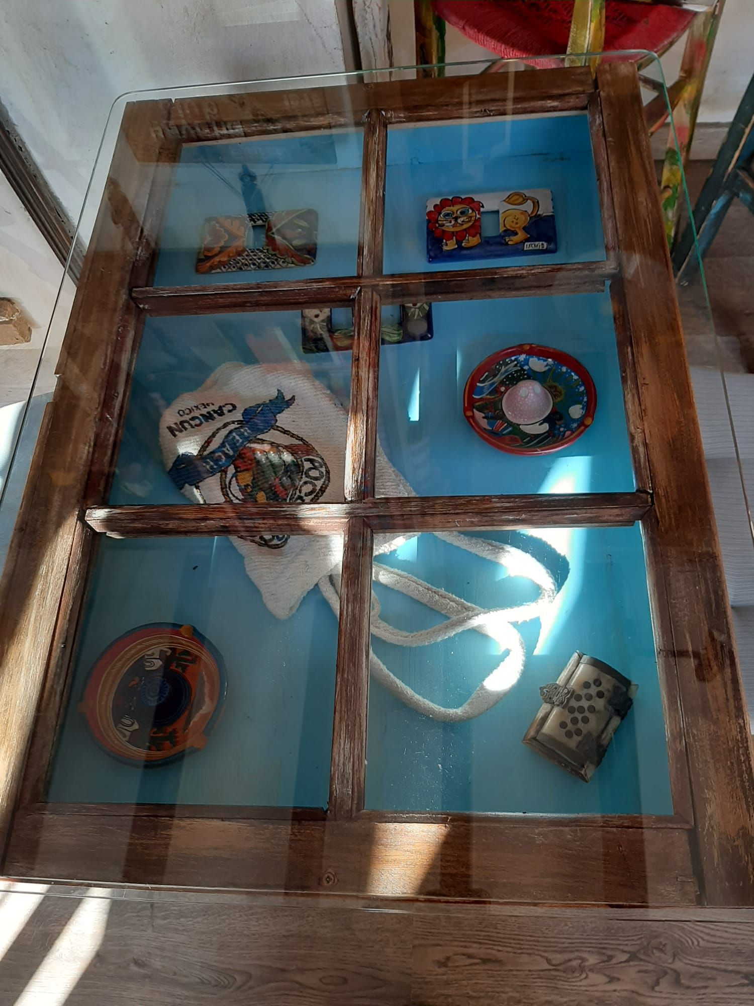 Una mesa de cristal con marco de madera y tapa de cristal.