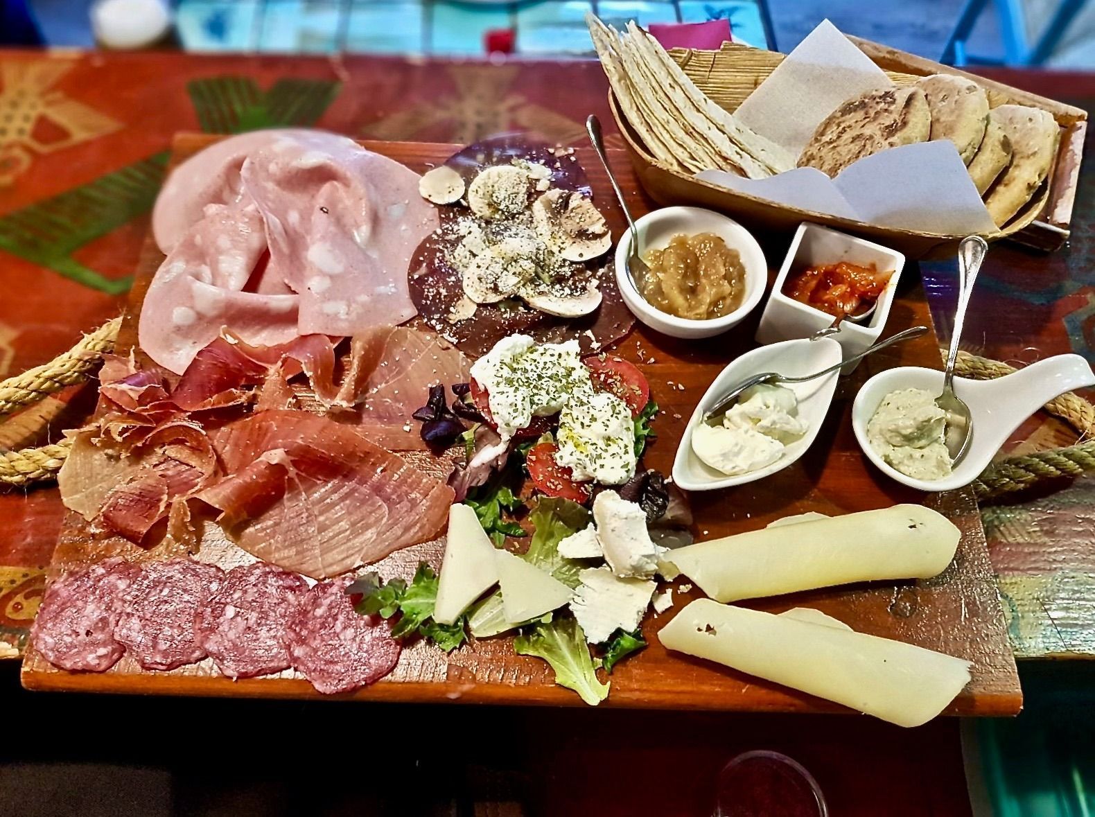 Una mesa de madera cubierta con una variedad de carnes y quesos.