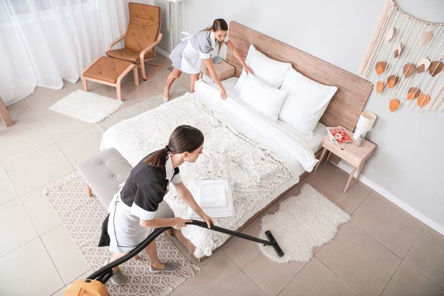 Deux femmes de ménage qui nettoient une chambre