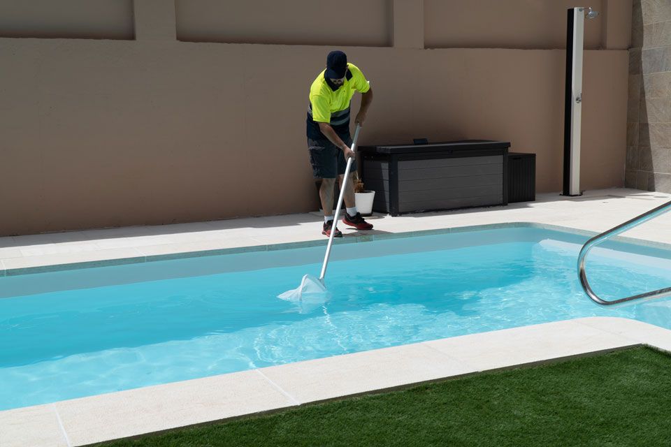 Une personne qui nettoie une piscine