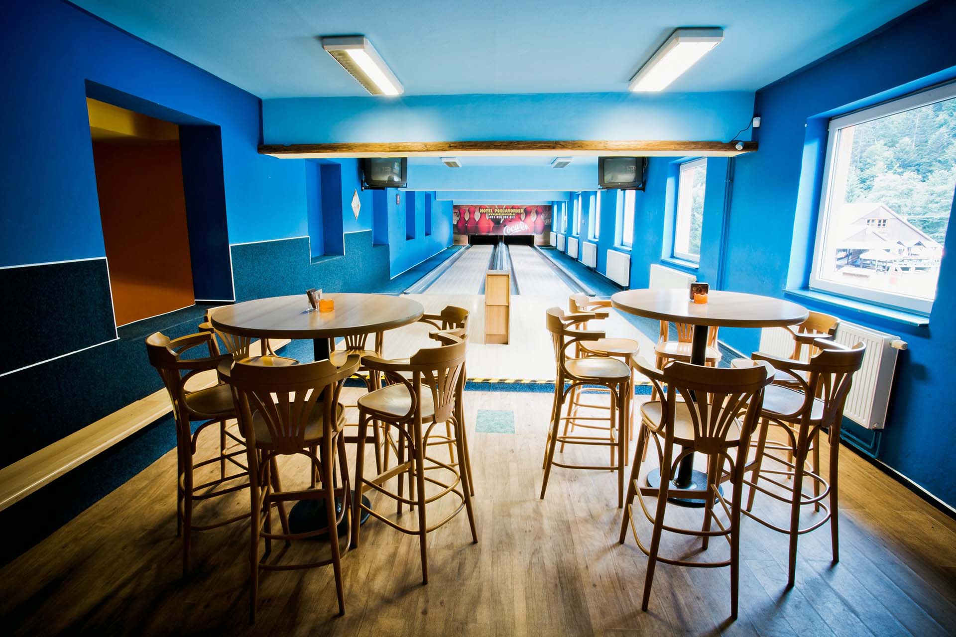 Deux tables de comptoir entourées de chaises dans un bowling