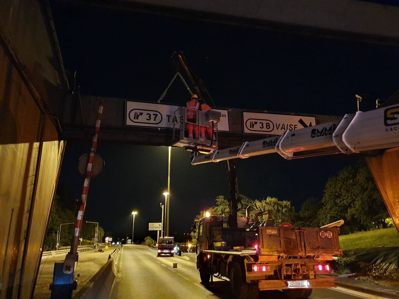 Ouvrier sur une nacelle de location, remplaçant un panneau de signalisation