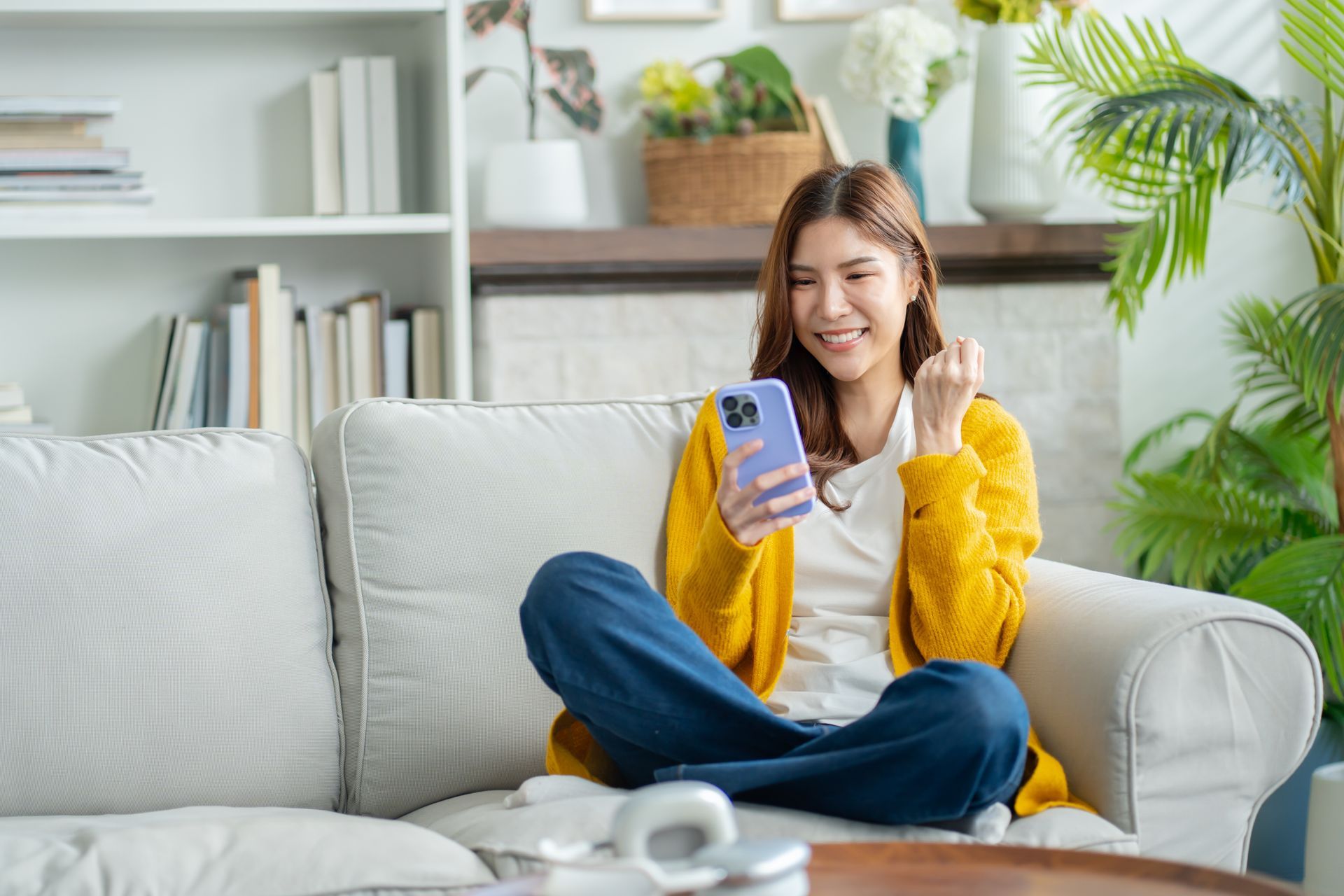 Une personne sur un canapé avec un portable.