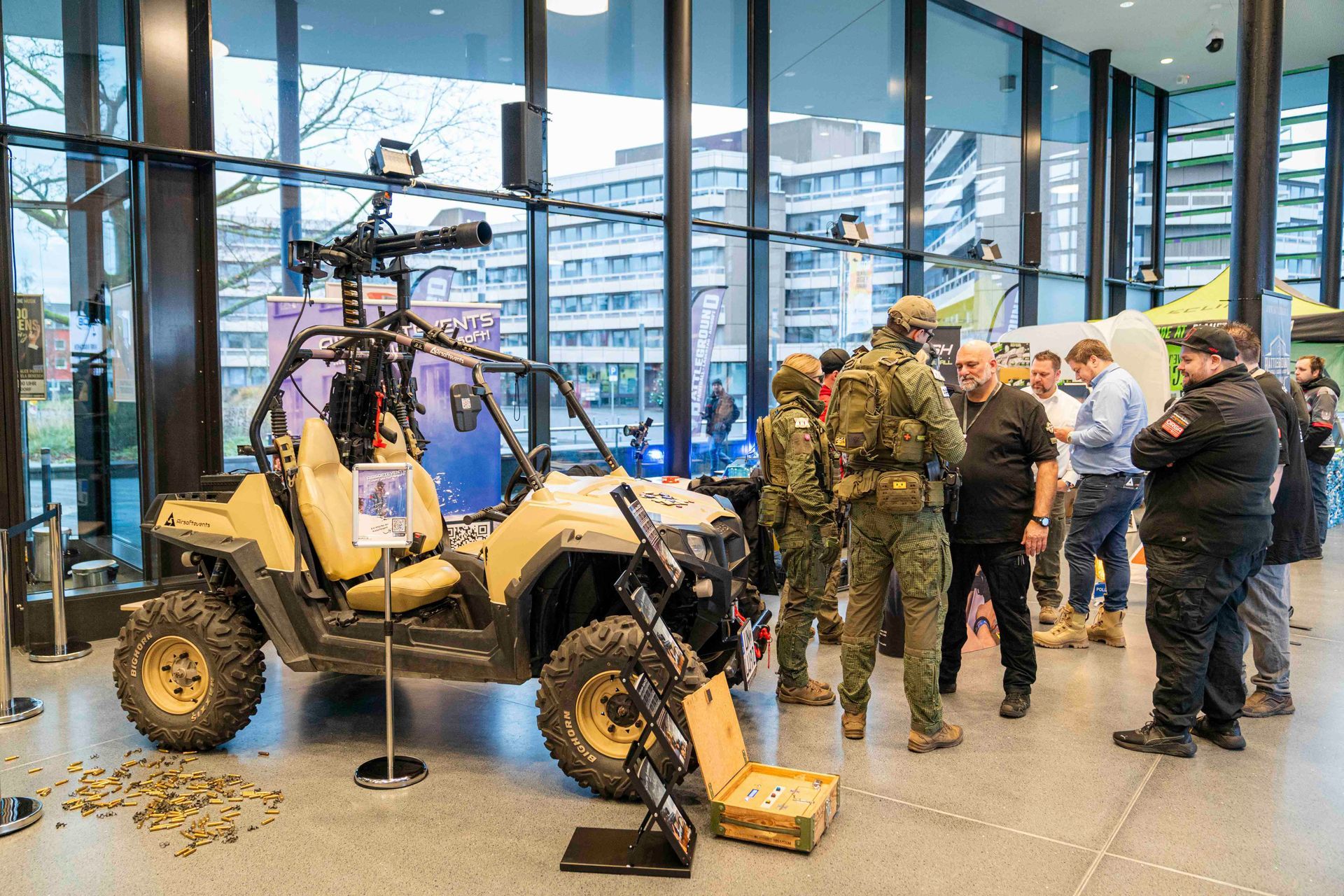 Ein Militärfahrzeug wird ausgestellt, umgeben von Personen in Uniformen und Freizeitkleidung