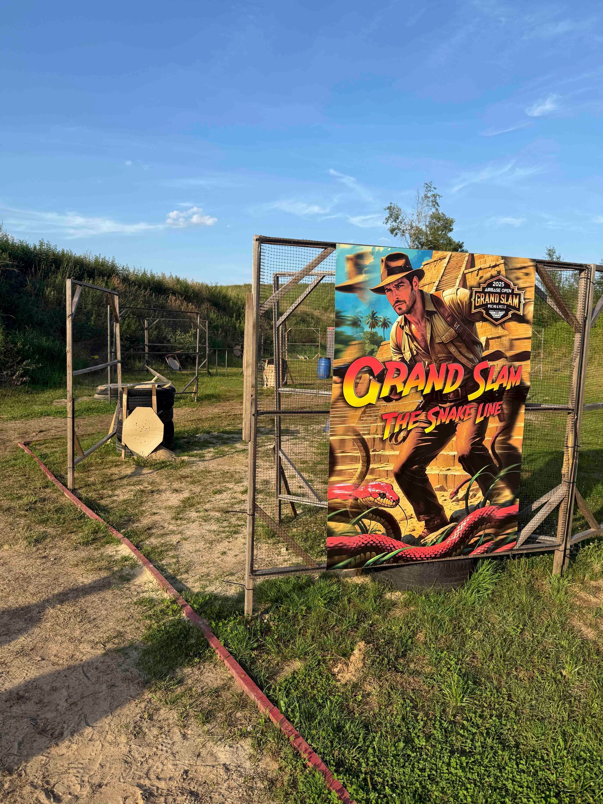 Schießstand mit einer großen Zielscheibe im Indiana-Jones-Stil und einer runden Zielscheibe. Bewölkter Himmel.