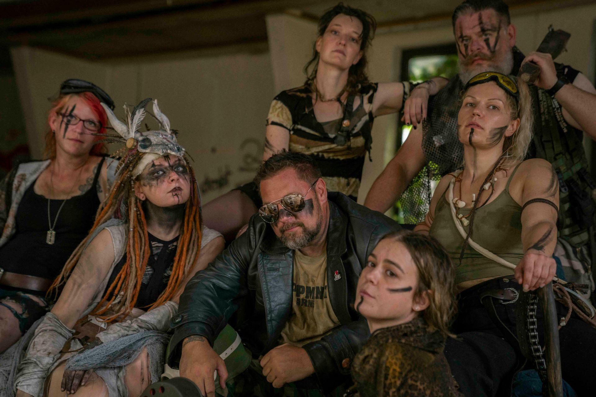 Eine Gruppe von Menschen in postapokalyptischer Kleidung, mit Schmutz und Gesichtsbemalung beschmiert