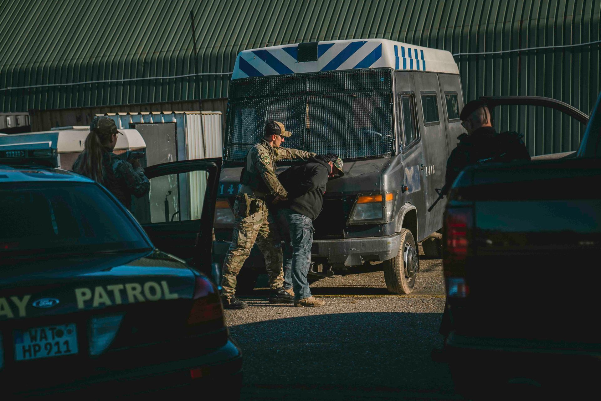 Die Polizei nimmt eine Person in der Nähe eines Lieferwagens und zweier Streifenwagen fest.