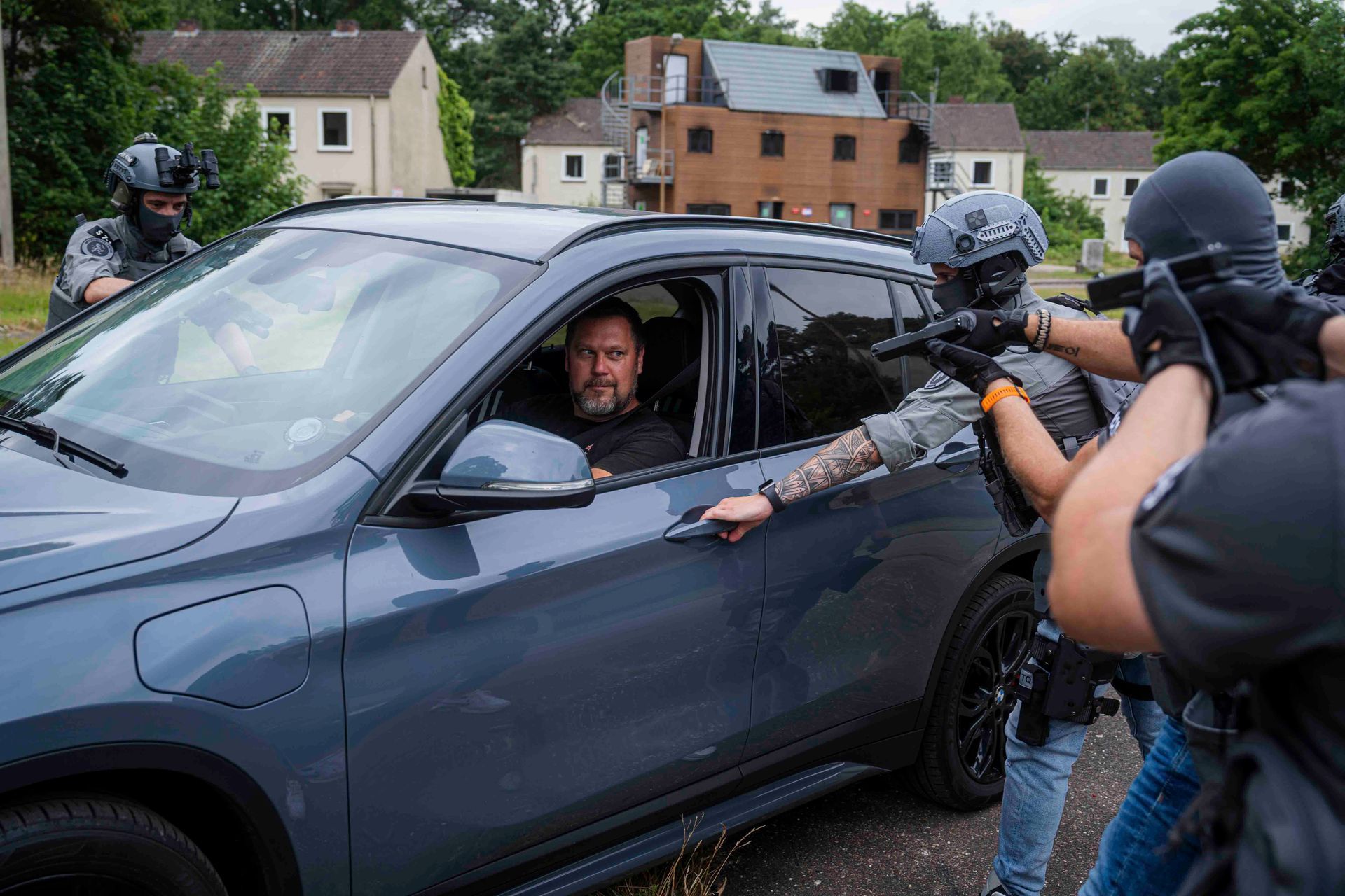Ein SEK-Team umstellt ein Fahrzeug, die Waffen sind gezogen. Der Mann im Auto blickt zu den Beamten.