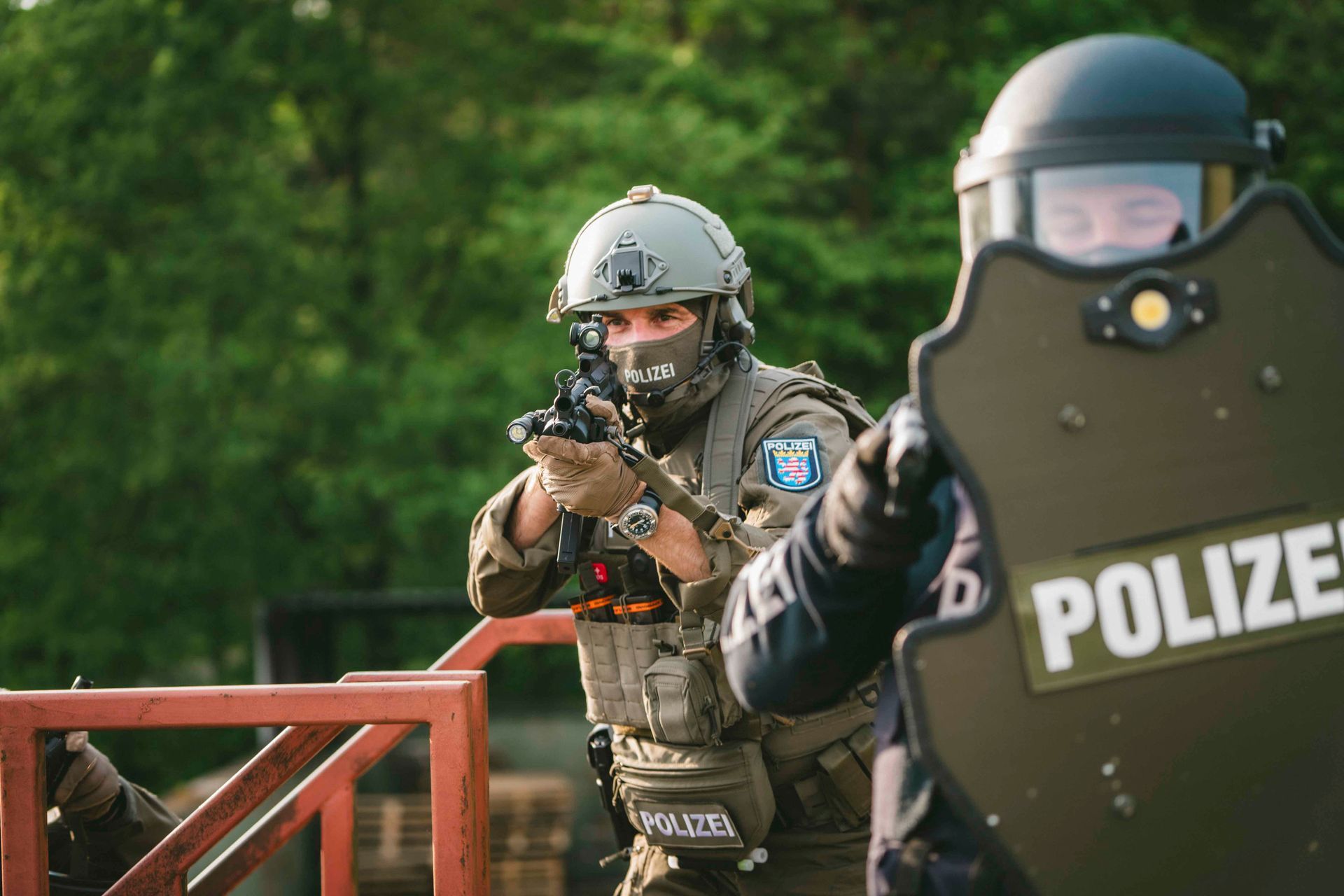 Ein Mitglied des SWAT-Teams zielt während eines Einsatzes mit seiner Waffe, geschützt durch einen Schild.