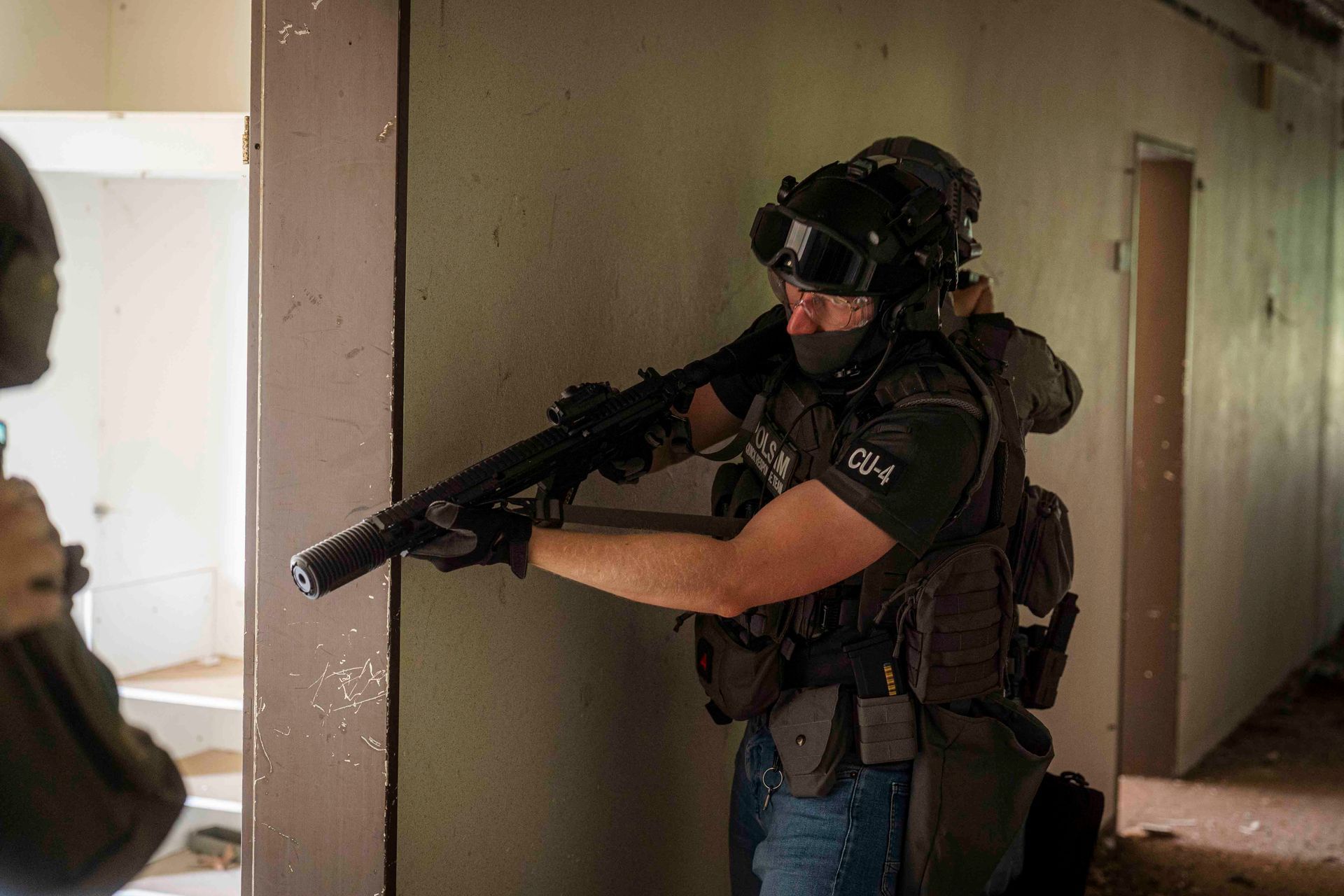 Ein Mitglied des SWAT-Teams zielt mit einer Schrotflinte in einem Gebäude.