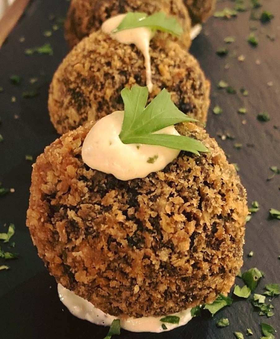 Un primer plano de un plato de comida con una hoja verde encima.