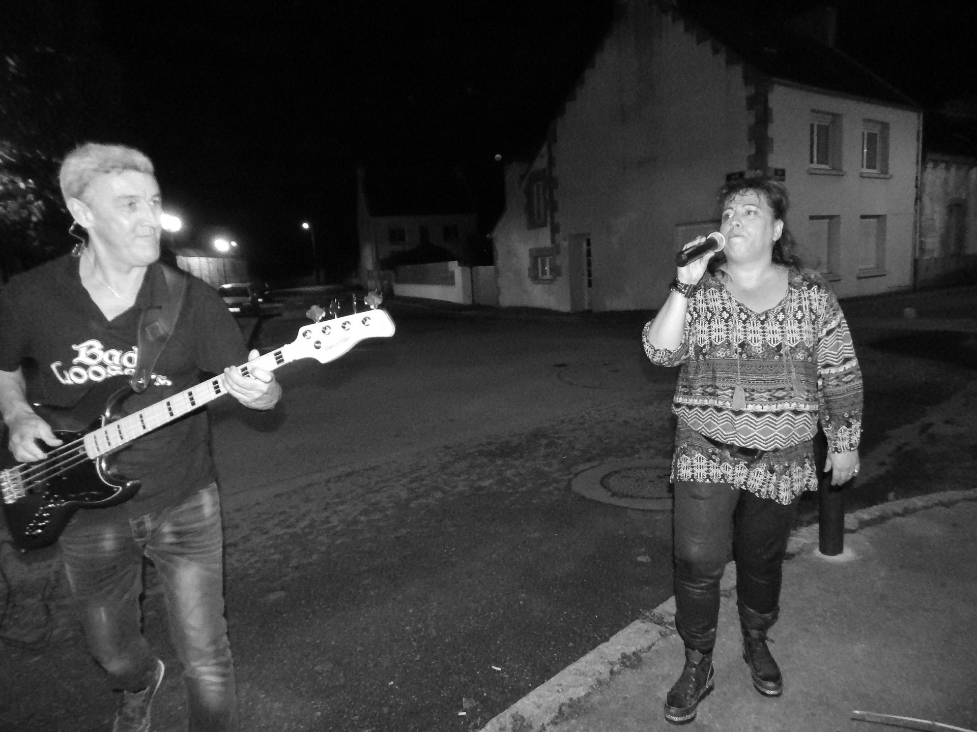 Deux personnes dont une joue de la guitare et l'autre chante.