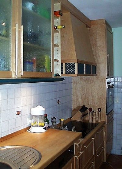 Küche mit Schränken und Arbeitsflächen aus Holz