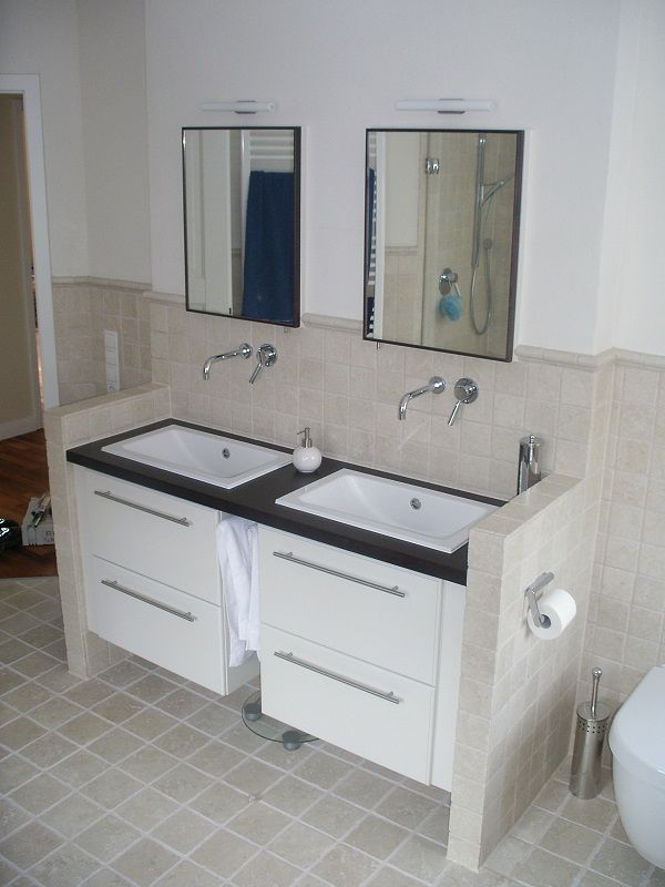 zwei Waschbecken mit Spiegeln in gefliestem Badezimmer