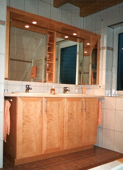 Waschbeckenbereich mit Spiegeln und Schränken in Holzoptik