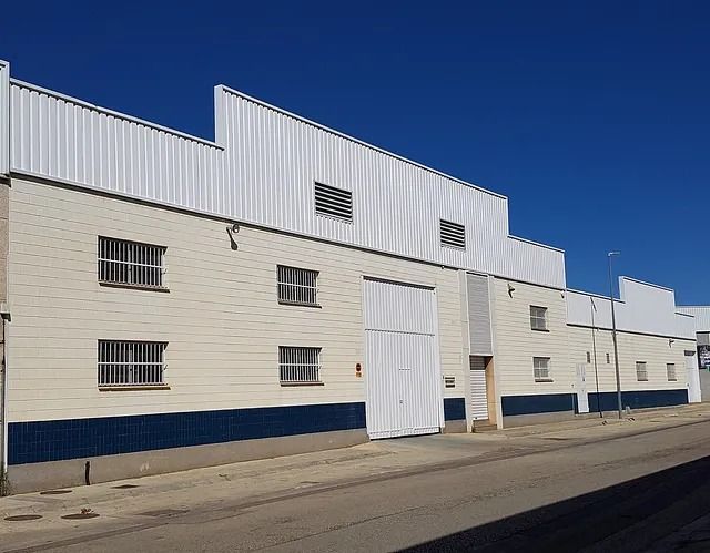 Un edificio blanco con una franja azul en el costado.