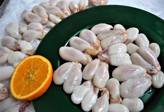 Un plato de comida con una rodaja de naranja al lado.