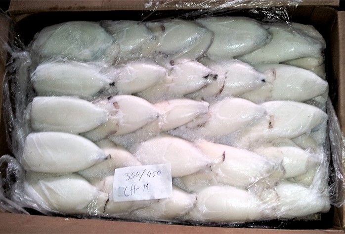 Una caja de calamares congelados está sobre una mesa.