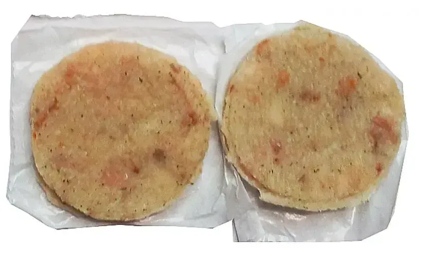 Dos tortillas chips envueltas en film plástico sobre un fondo blanco.