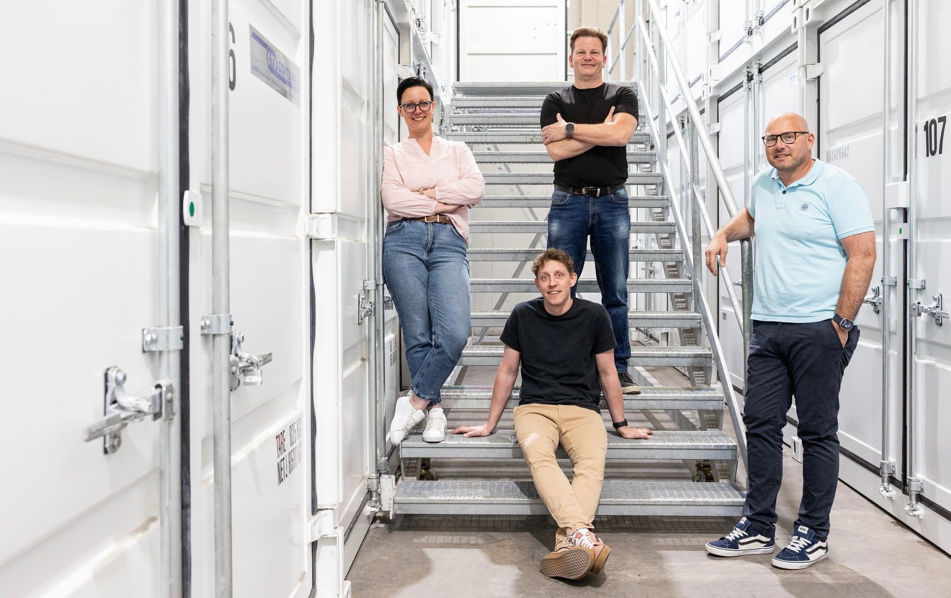 Eine Gruppe von Menschen steht nebeneinander auf einer Treppe.