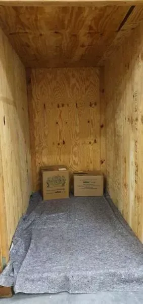 Eine Holzkiste mit zwei Pappkartons darin.