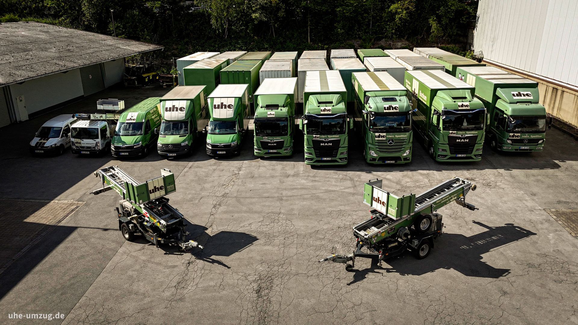 Eine Reihe grüner Lastwagen stehen auf einem Parkplatz