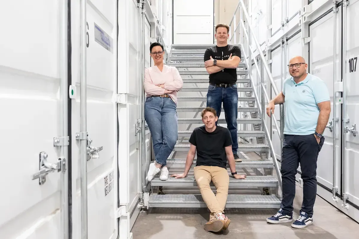 Eine Gruppe von Menschen steht nebeneinander auf einer Treppe.
