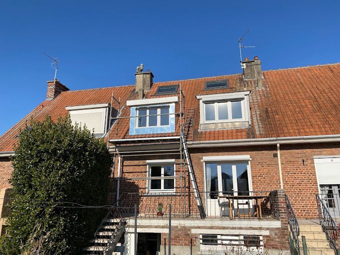 Une maison avec une toiture en tuiles et des fenêtres.